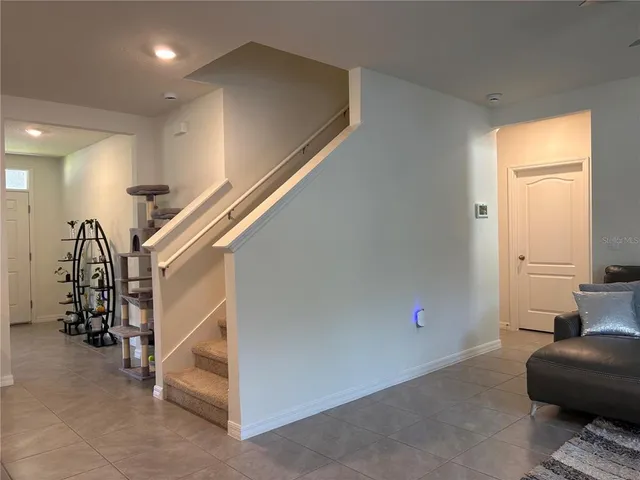a living room with a couch a window and a flat screen tv
