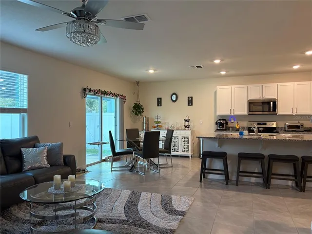a kitchen with stainless steel appliances granite countertop a refrigerator a sink and white cabinets