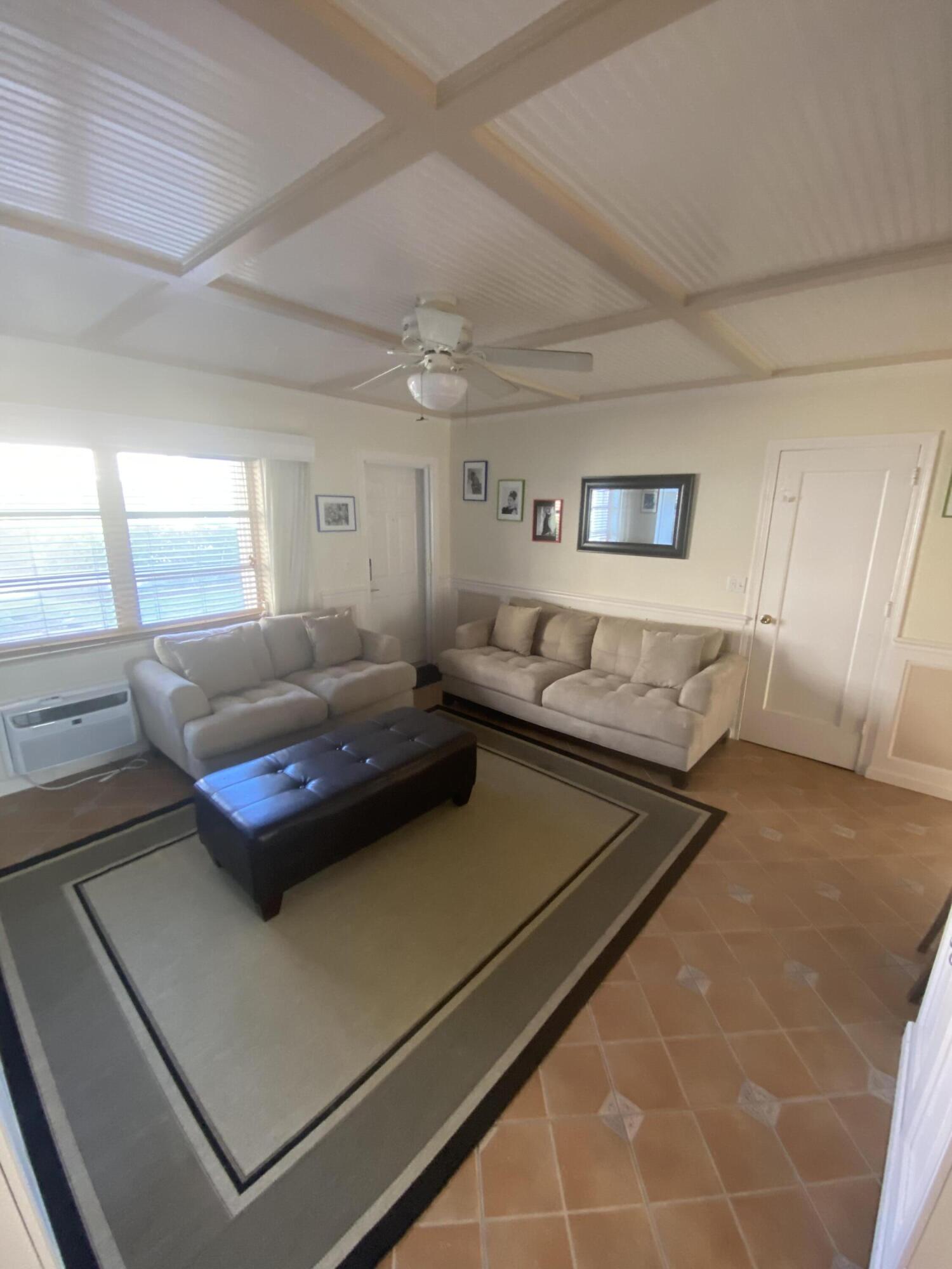 101 South Golfview Road, Unit 5 Lake Worth Beach, FL 33460 - Photo 11 of 17 a living room with a bed furniture and a large window