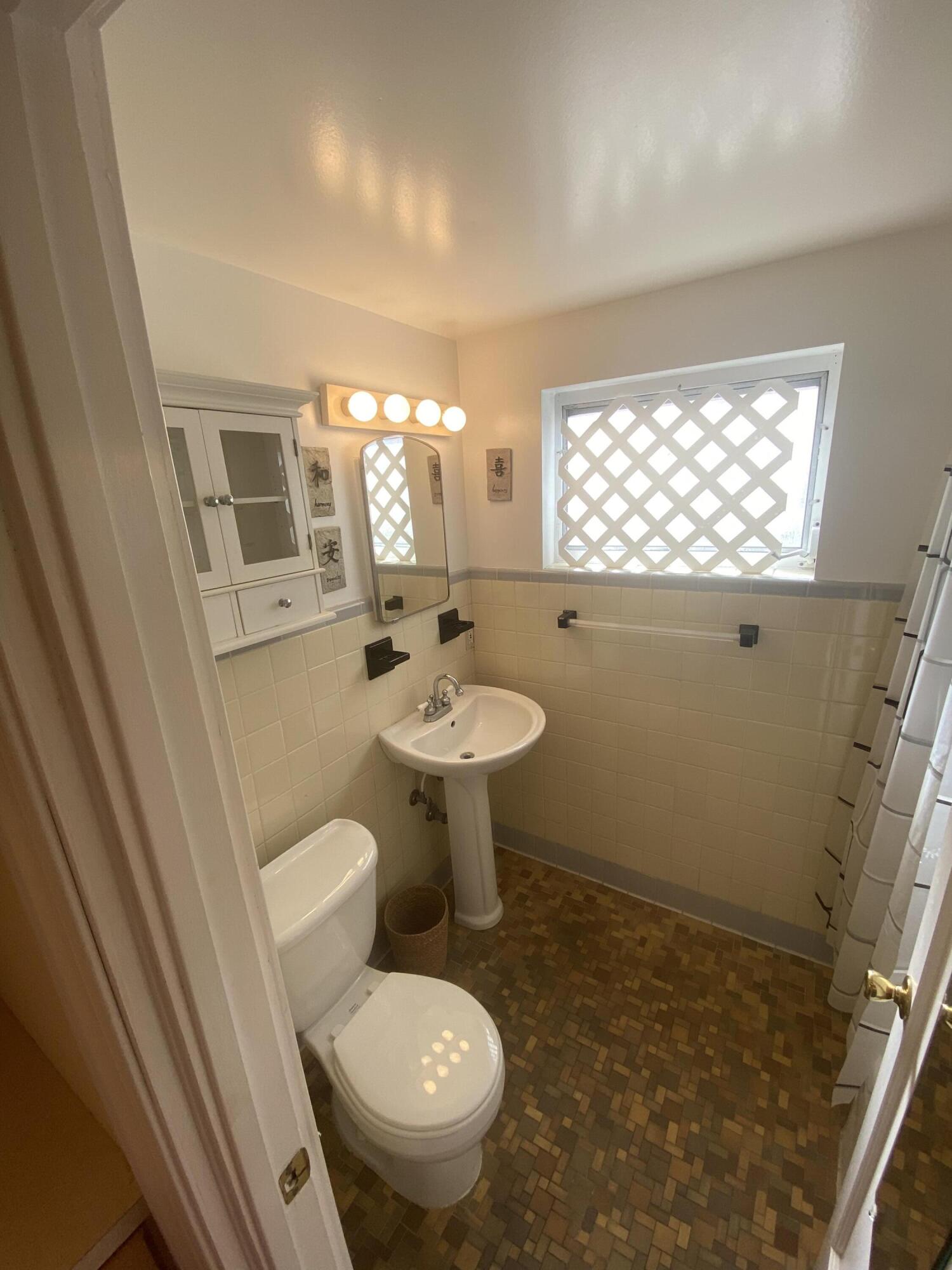 101 South Golfview Road, Unit 5 Lake Worth Beach, FL 33460 - Photo 15 of 17 a bathroom with a sink toilet and window