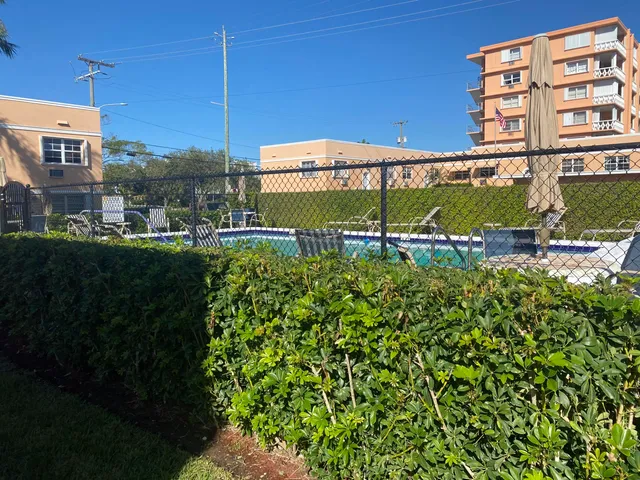 a view of a building with a garden and signage