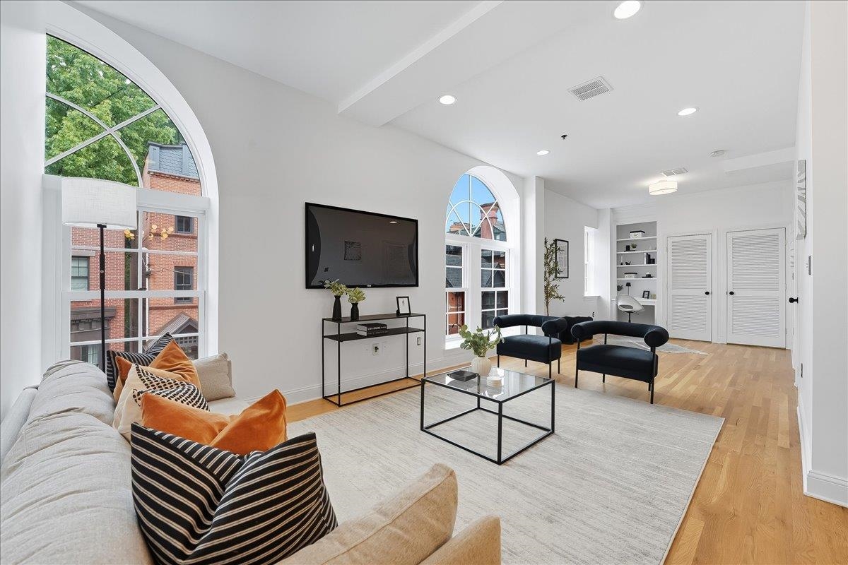 829 Washington Street, Unit 8 Hoboken, NJ 07030 - Photo 1 of 36 a living room with furniture a flat screen tv and a large window