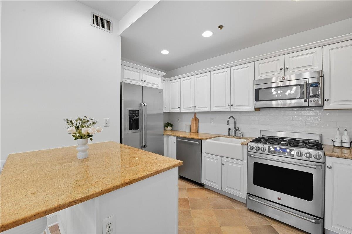 829 Washington Street, Unit 8 Hoboken, NJ 07030 - Photo 18 of 36 a kitchen with stainless steel appliances granite countertop a stove a sink and a refrigerator