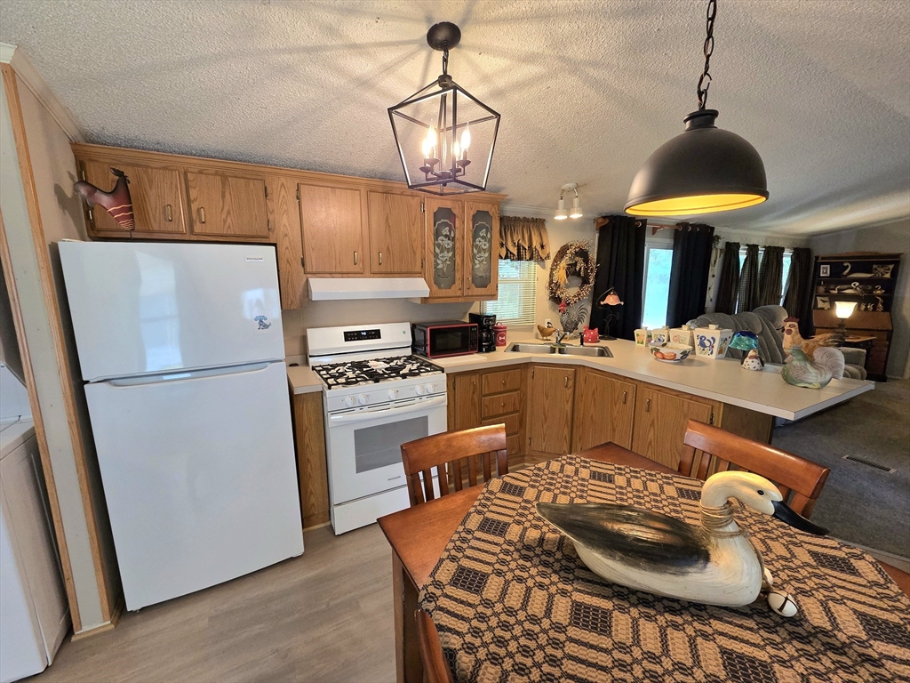 72 Holiday Circle Chicopee, MA 01020 - Photo 6 of 16 a kitchen with a refrigerator a stove a sink and a dining table
