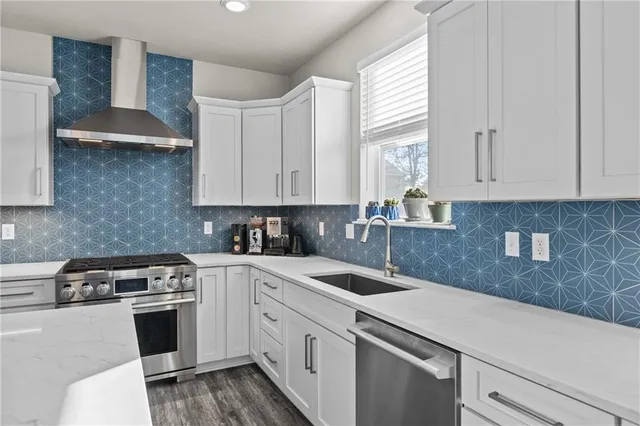 a kitchen with stainless steel appliances granite countertop a sink a stove and cabinets