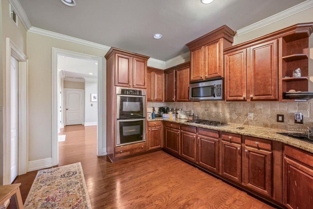 345 Masters Club Boulevard Hampton, GA 30228 - Photo 14 of 30 a kitchen with stainless steel appliances granite countertop a stove sink microwave and refrigerator