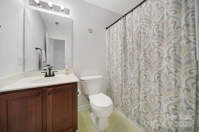 a bathroom with a granite countertop sink a toilet and a mirror