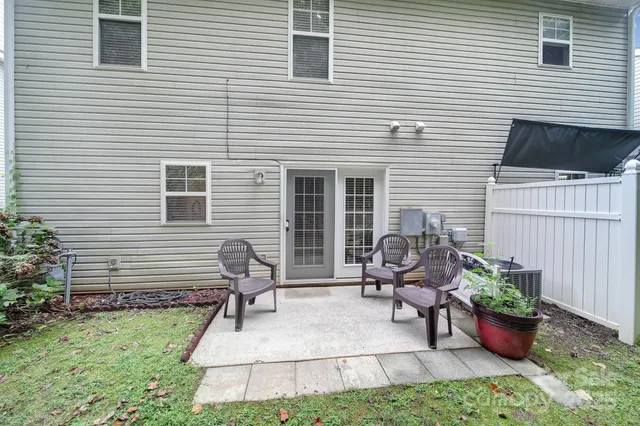 a view of a backyard with chair and potted plants