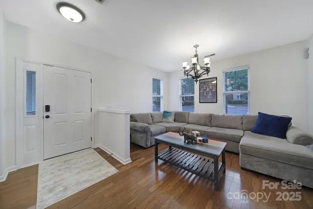 a living room with furniture and a chandelier