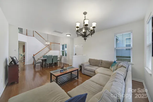 a living room with furniture a dining table and a chandelier