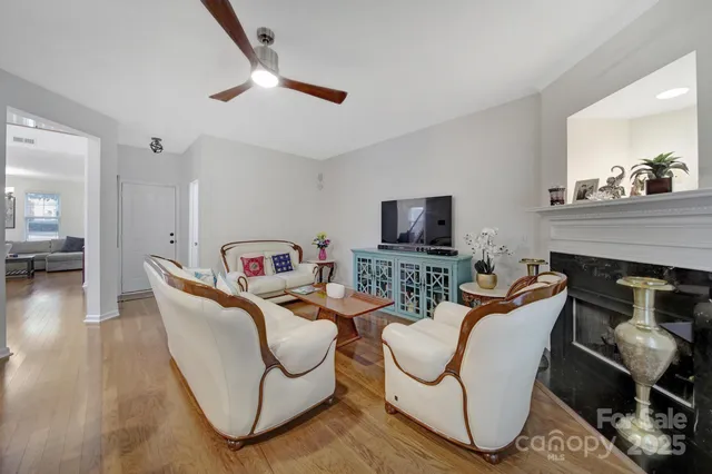 a living room with furniture a flat screen tv and kitchen view