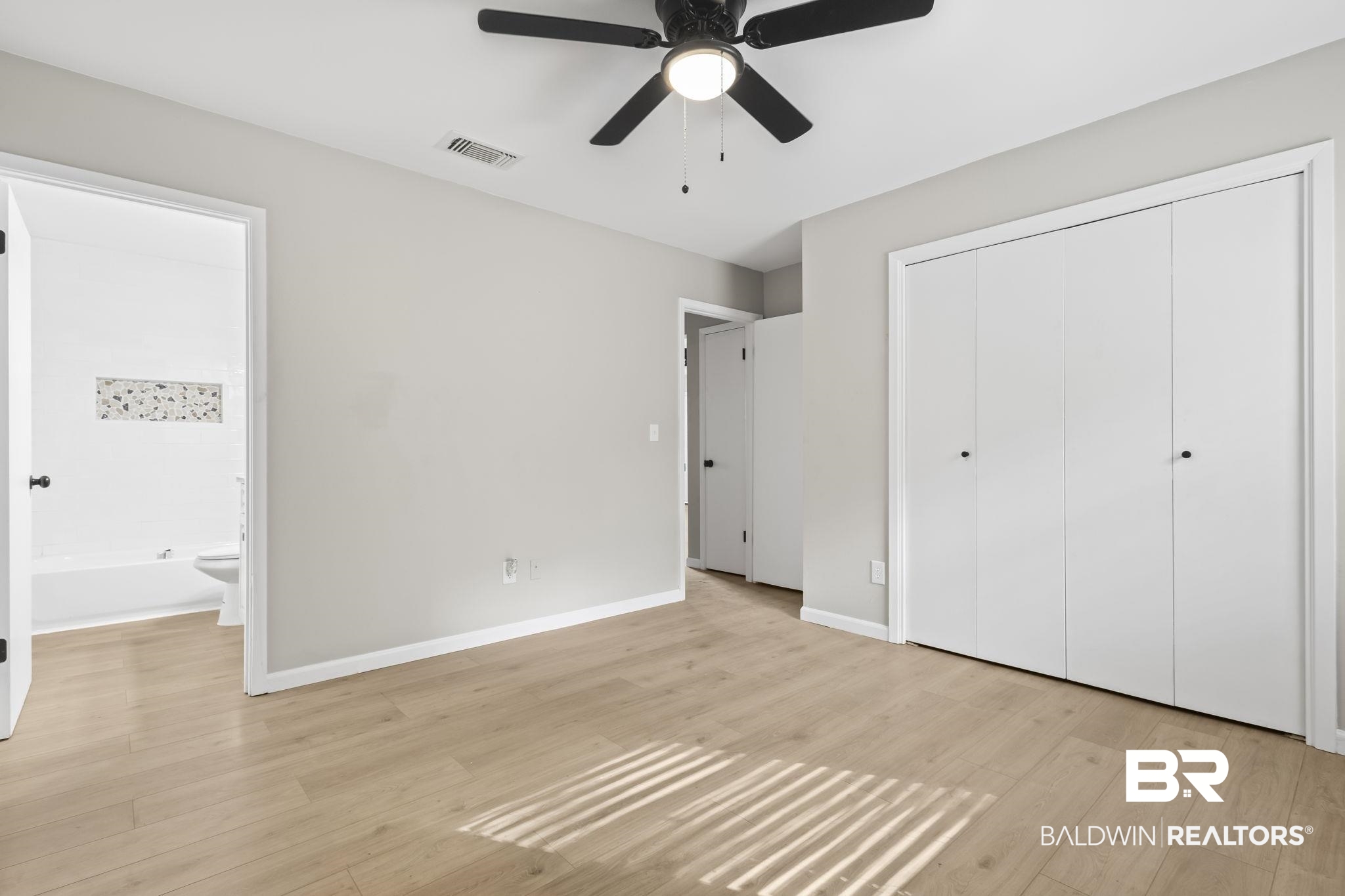 309 West Roosevelt Avenue Foley, AL 36535 - Photo 36 of 60 Unfurnished bedroom featuring a closet, light wood-type flooring, ensuite bathroom, and ceiling fan