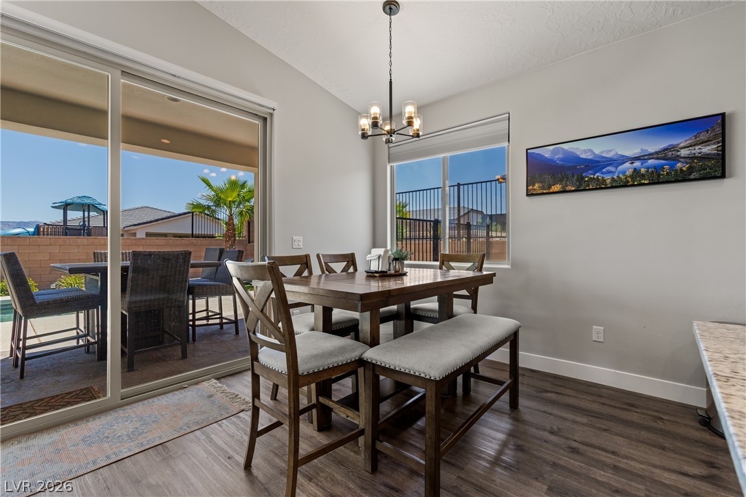 1436 Manassas Ridge Mesquite, NV 89027 - Photo 22 of 77 Natural light floods this dining area, featuring a contemporary light fixture and rich hardwood flooring.