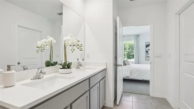 a en suite bathroom with a double vanity sink and a mirror