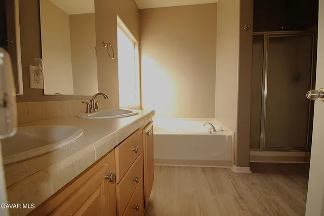 a bathroom with a tub sink and mirror