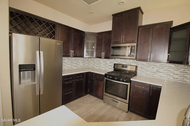 a kitchen with stainless steel appliances granite countertop a refrigerator stove and microwave