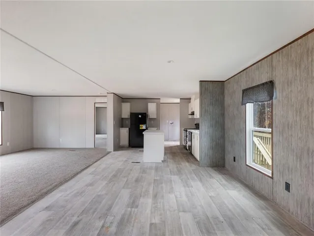 a view of a big room with wooden floor and windows