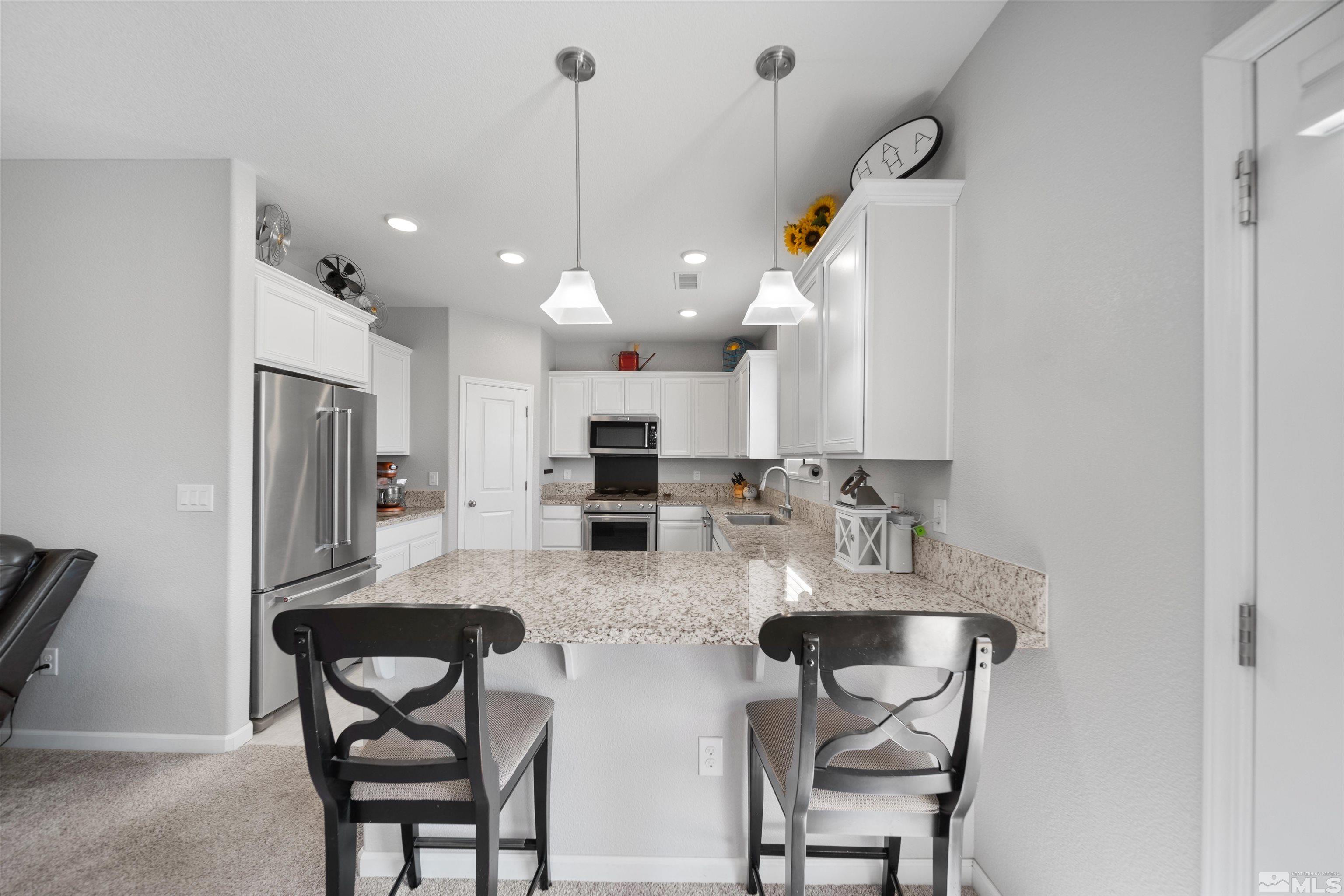 449 Scenic Ridge Drive Reno, NV 89506 - Photo 4 of 22 a kitchen with refrigerator and chairs