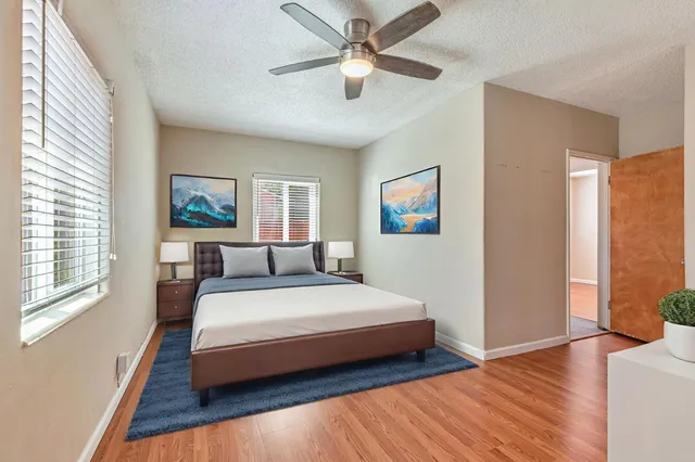 an empty room with windows and ceiling fan