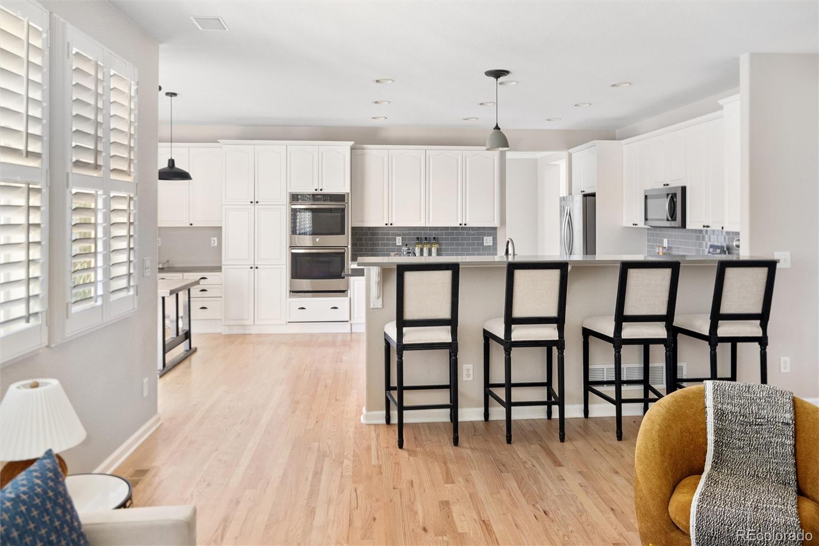 2836 Rockbridge Circle Highlands Ranch, CO 80129 - Photo 17 of 50 a kitchen with stainless steel appliances granite countertop a stove top oven a sink a dining table and chairs with wooden floor