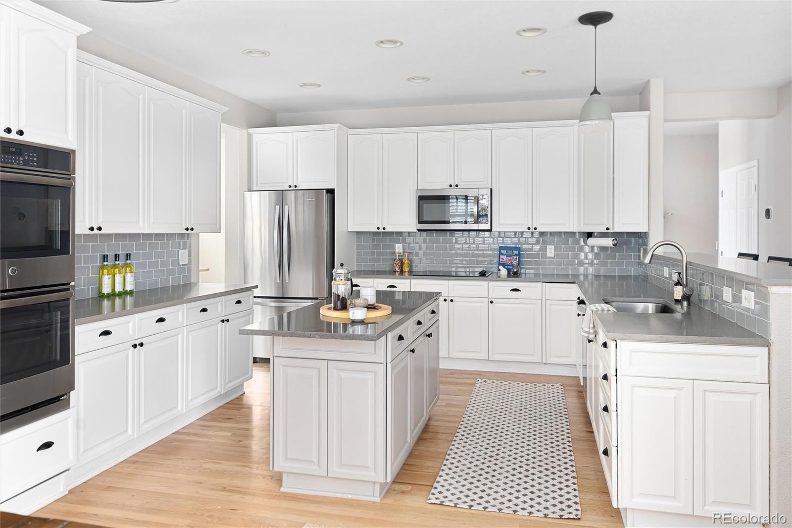 2836 Rockbridge Circle Highlands Ranch, CO 80129 - Photo 19 of 50 a kitchen with stainless steel appliances a sink a stove a refrigerator cabinets and a window
