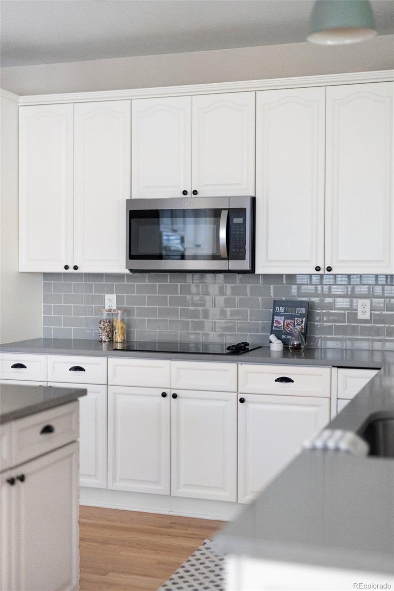 2836 Rockbridge Circle Highlands Ranch, CO 80129 - Photo 20 of 50 a kitchen with stainless steel appliances granite countertop a sink a stove and white cabinets