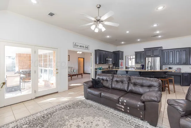 a kitchen with stainless steel appliances a table chairs refrigerator and cabinets