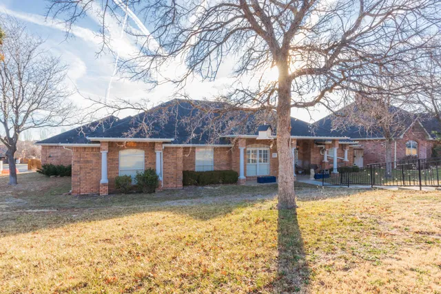a front view of a house with a yard covered with snow