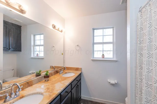 a bathroom with a granite countertop sink and a mirror