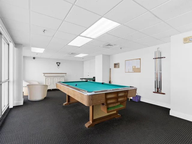 a room with pool table and windows