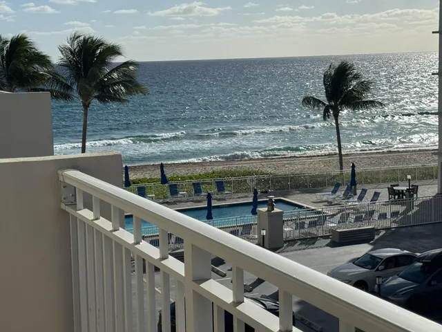 a view of a balcony with wooden floor and iron fence