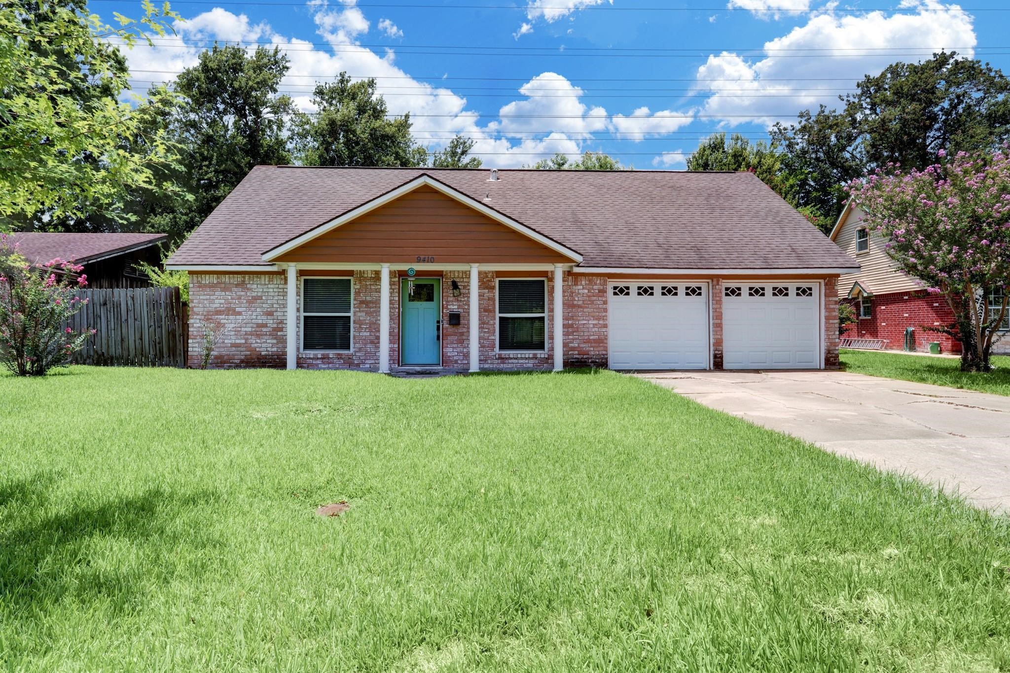 a front view of a house with a garden and yard