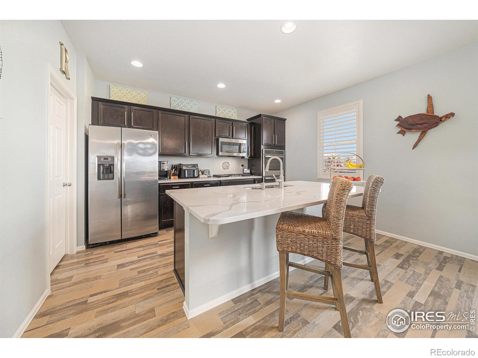6778 Coach Light Court Timnath, CO 80547 - Photo 8 of 36 a kitchen with stainless steel appliances a refrigerator and a table