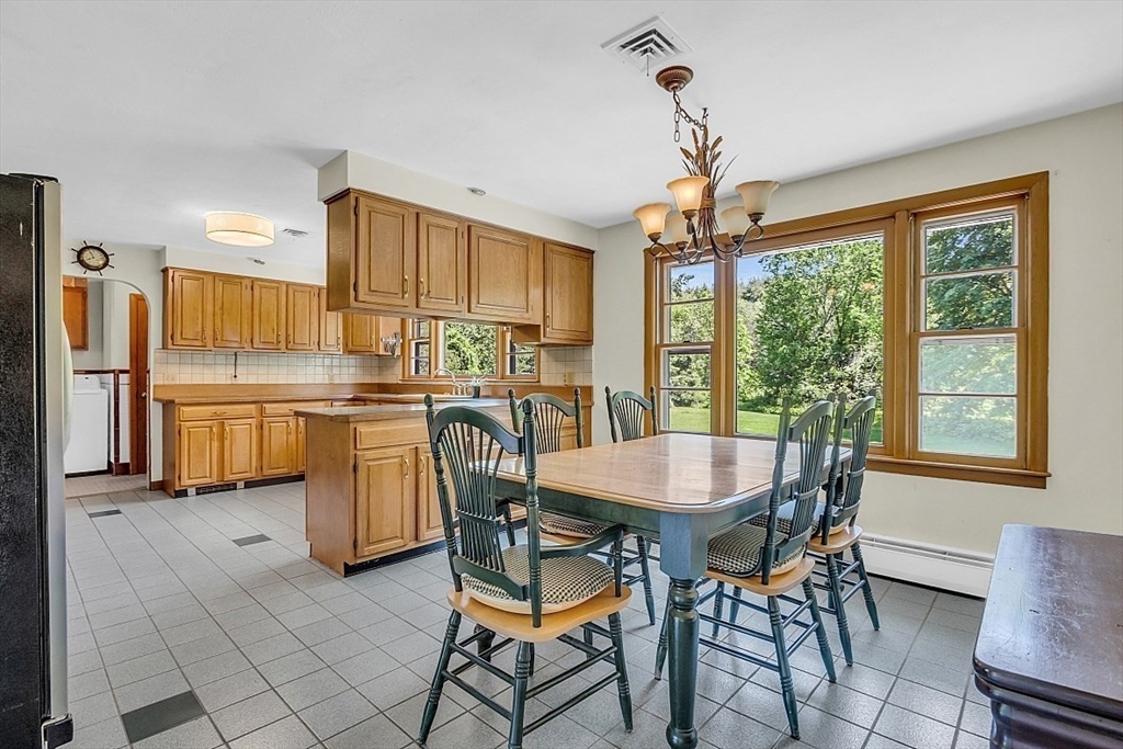 233 West Acton Road Stow, MA 01775 - Photo 11 of 41 a dining room with furniture a large window and kitchen view