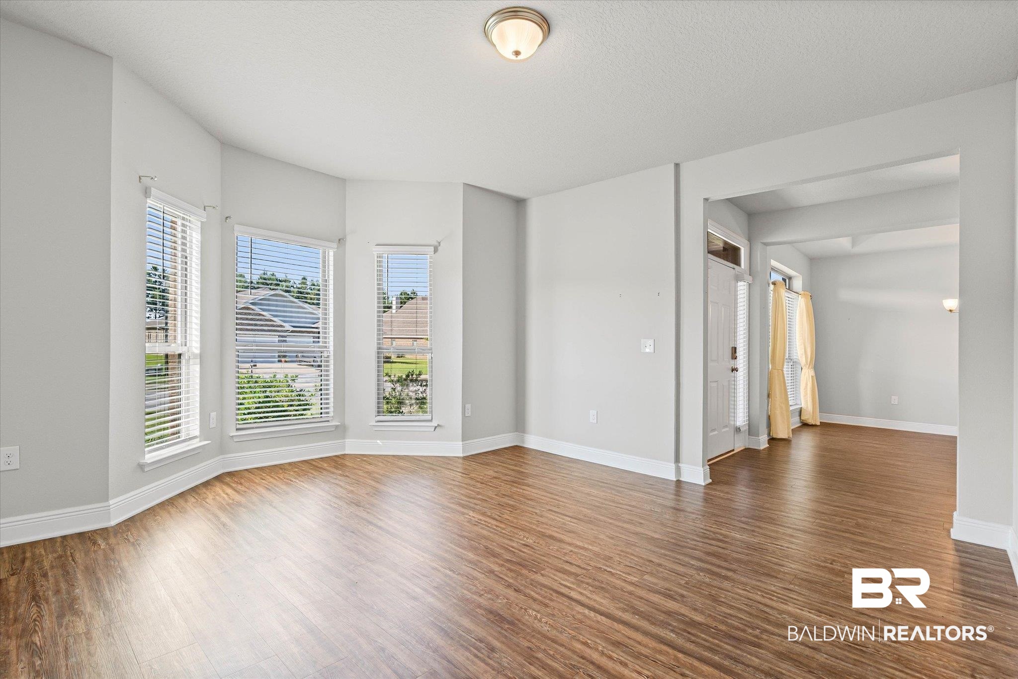 10207 Dunleith Loop Daphne, AL 36526 - Photo 7 of 23 Empty room featuring dark wood-style floors and baseboards
