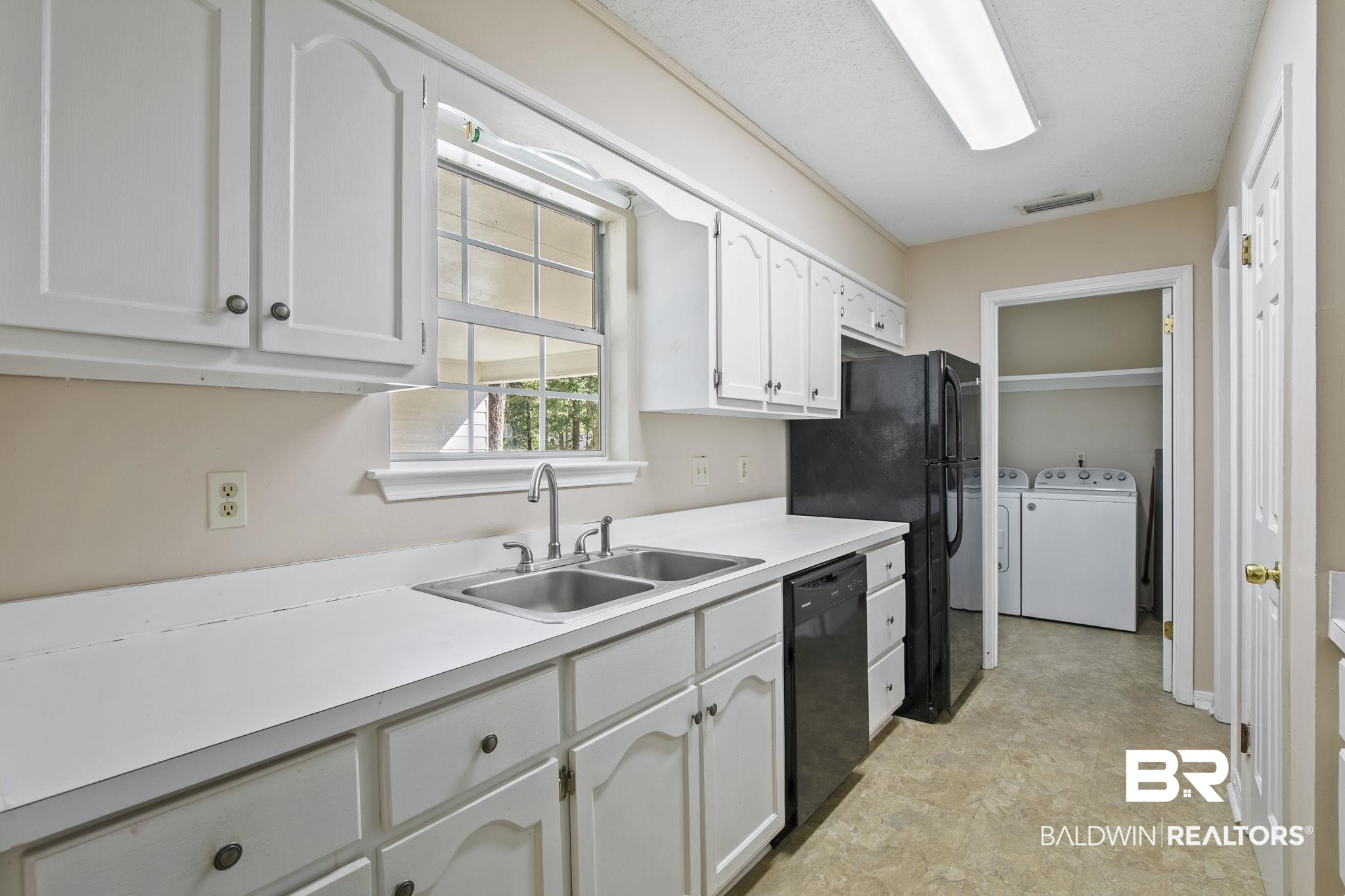 359 Ridgewood Drive Daphne, AL 36526 - Photo 20 of 73 Kitchen with white cabinetry, black appliances, sink, and washing machine and clothes dryer