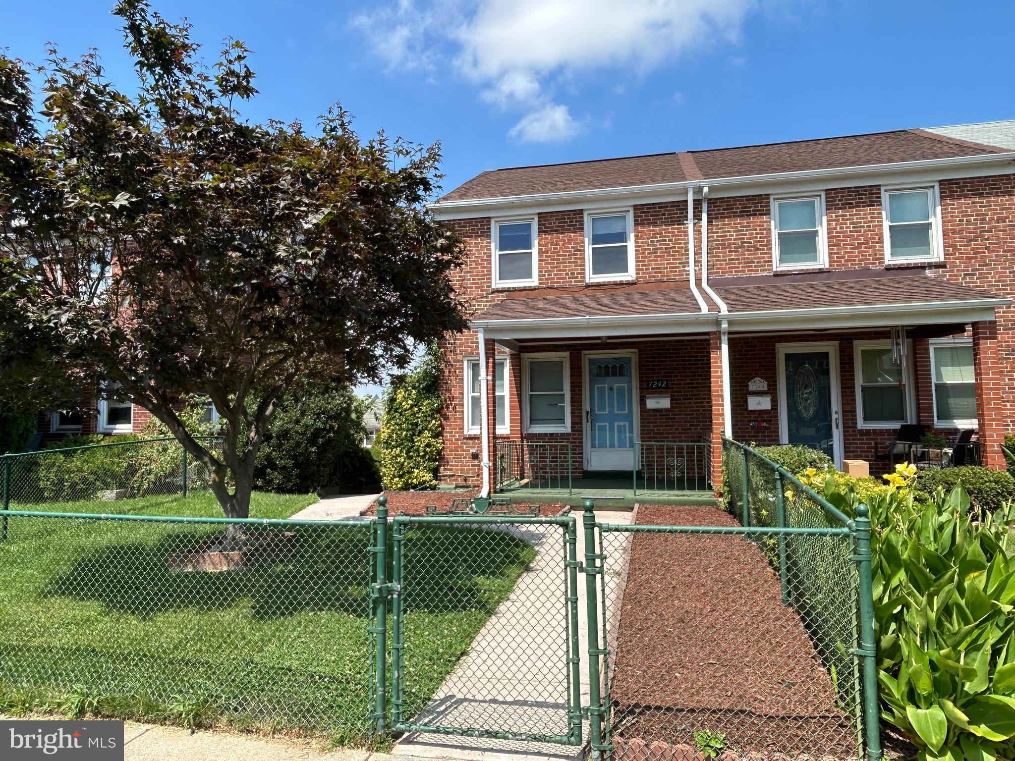 front view of a brick house with a yard