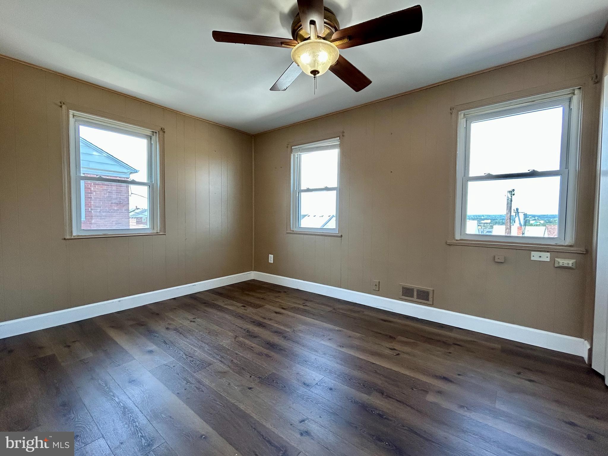 7242 Conley Street Baltimore, MD 21224 - Photo 11 of 18 a view of an empty room with wooden floor and a window