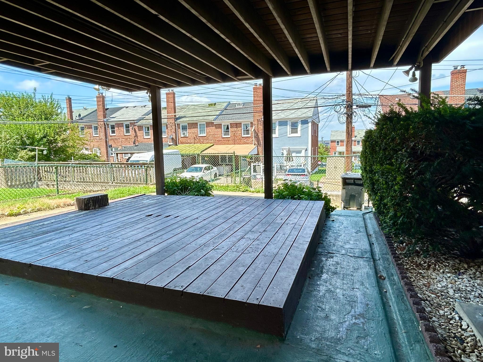 7242 Conley Street Baltimore, MD 21224 - Photo 16 of 18 a patio with wooden floor a yard a table and chairs