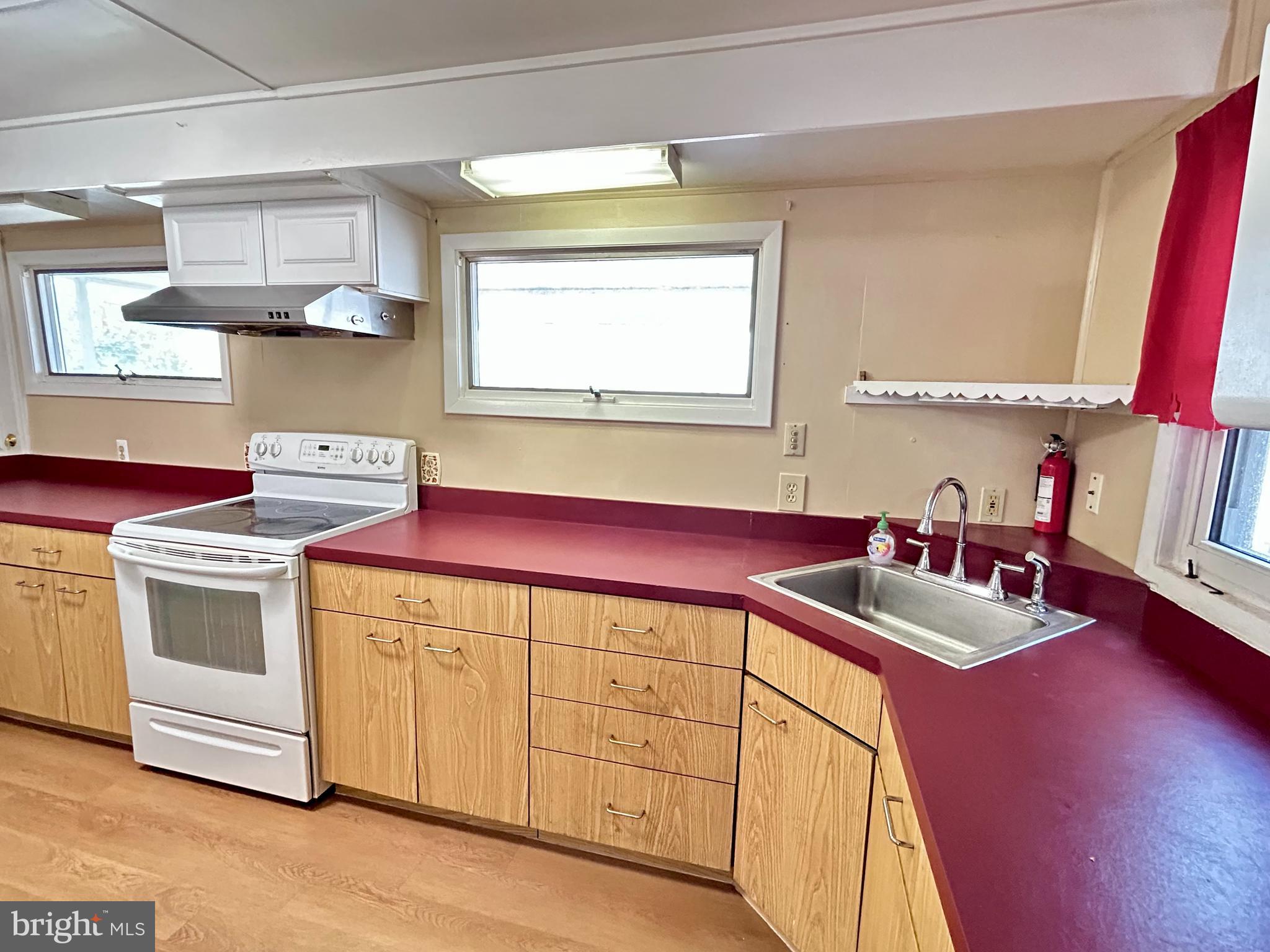 7242 Conley Street Baltimore, MD 21224 - Photo 8 of 18 a kitchen with stainless steel appliances a stove a sink and a microwave