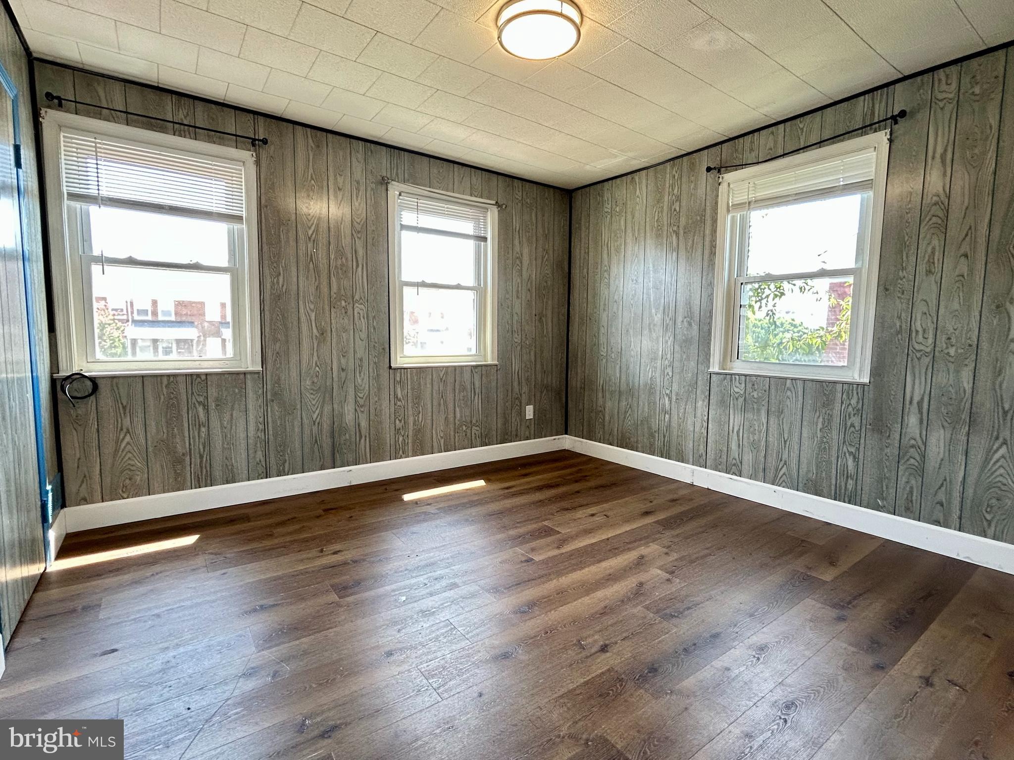 7242 Conley Street Baltimore, MD 21224 - Photo 10 of 18 an empty room with wooden floor and windows