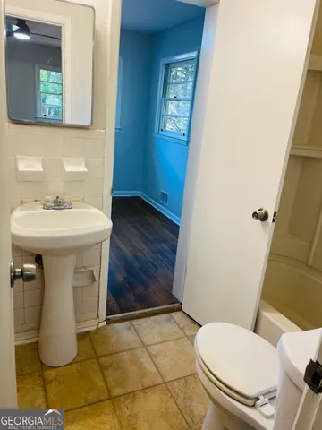 a bathroom with a sink toilet and mirror