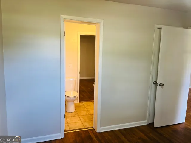 an empty room with wooden floor and entrance
