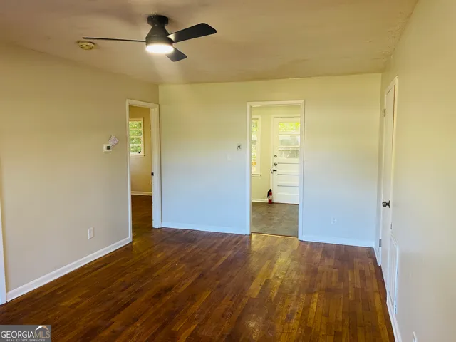 a view of a big room with wooden floor and a ceiling fan