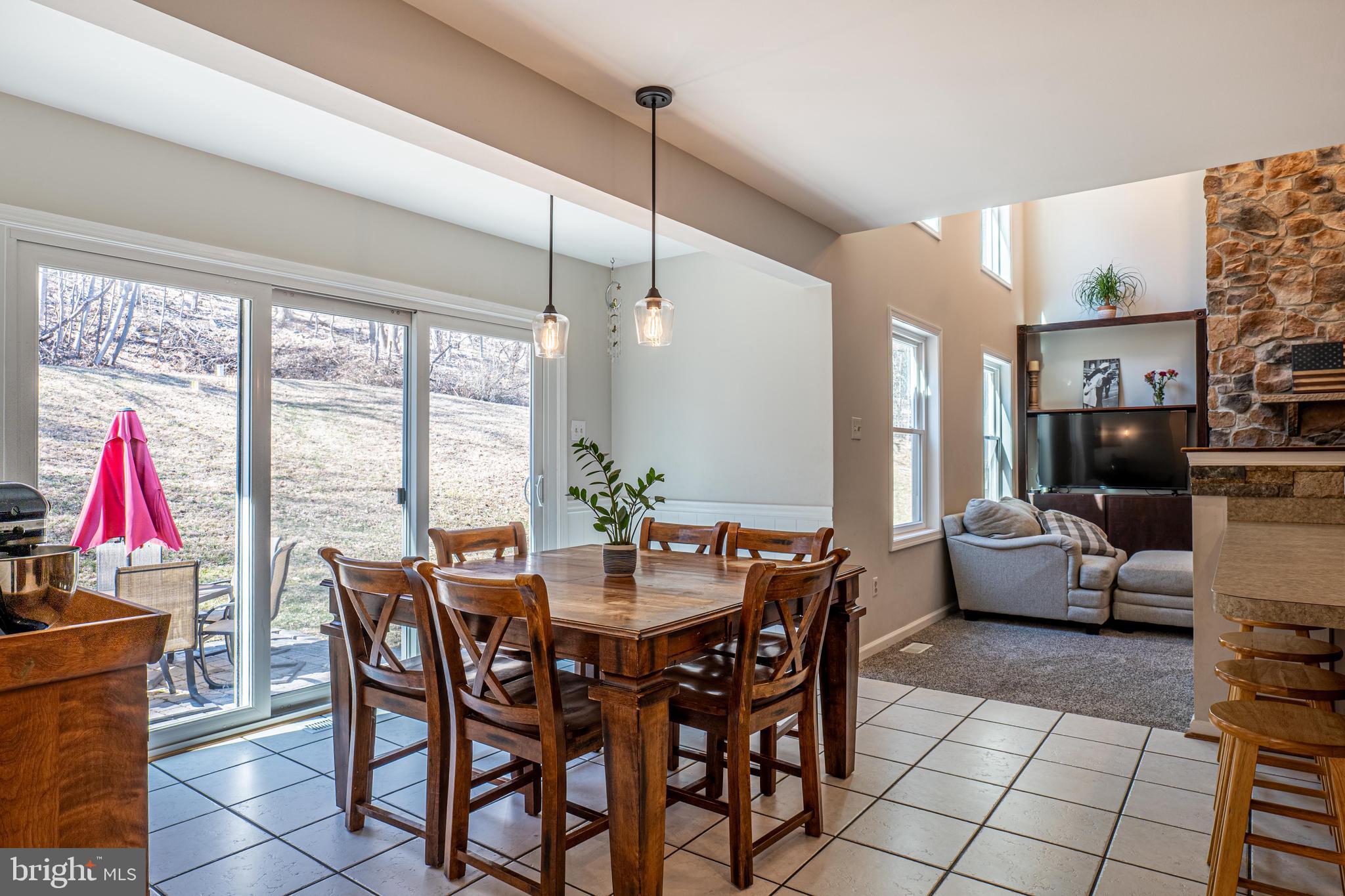 9833 Fox Road Frederick, MD 21702 - Photo 22 of 48 a view of a dining room and livingroom with furniture large windows a chandelier