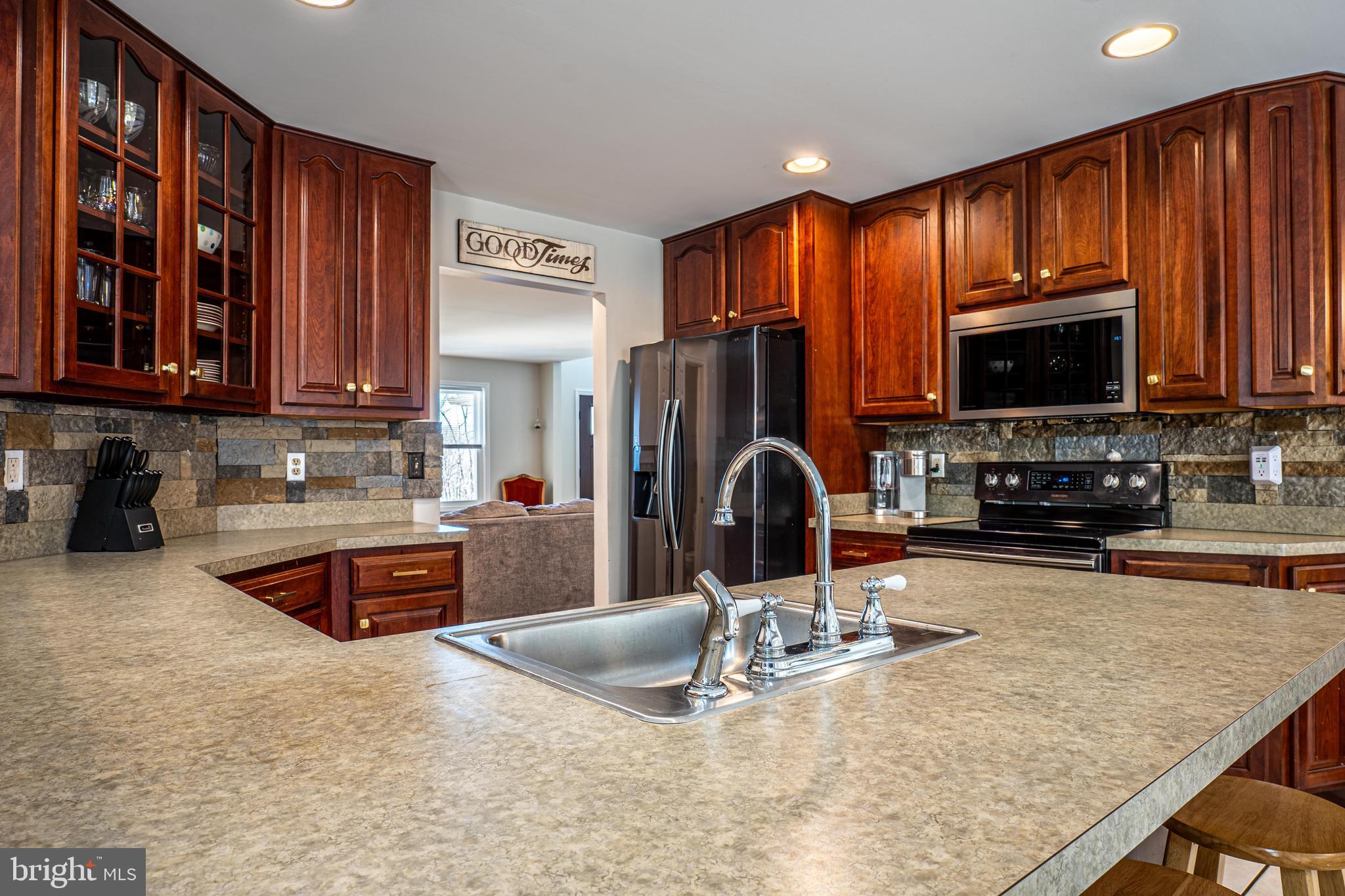 9833 Fox Road Frederick, MD 21702 - Photo 27 of 48 a kitchen with stainless steel appliances granite countertop a stove a sink a microwave a refrigerator and cabinets