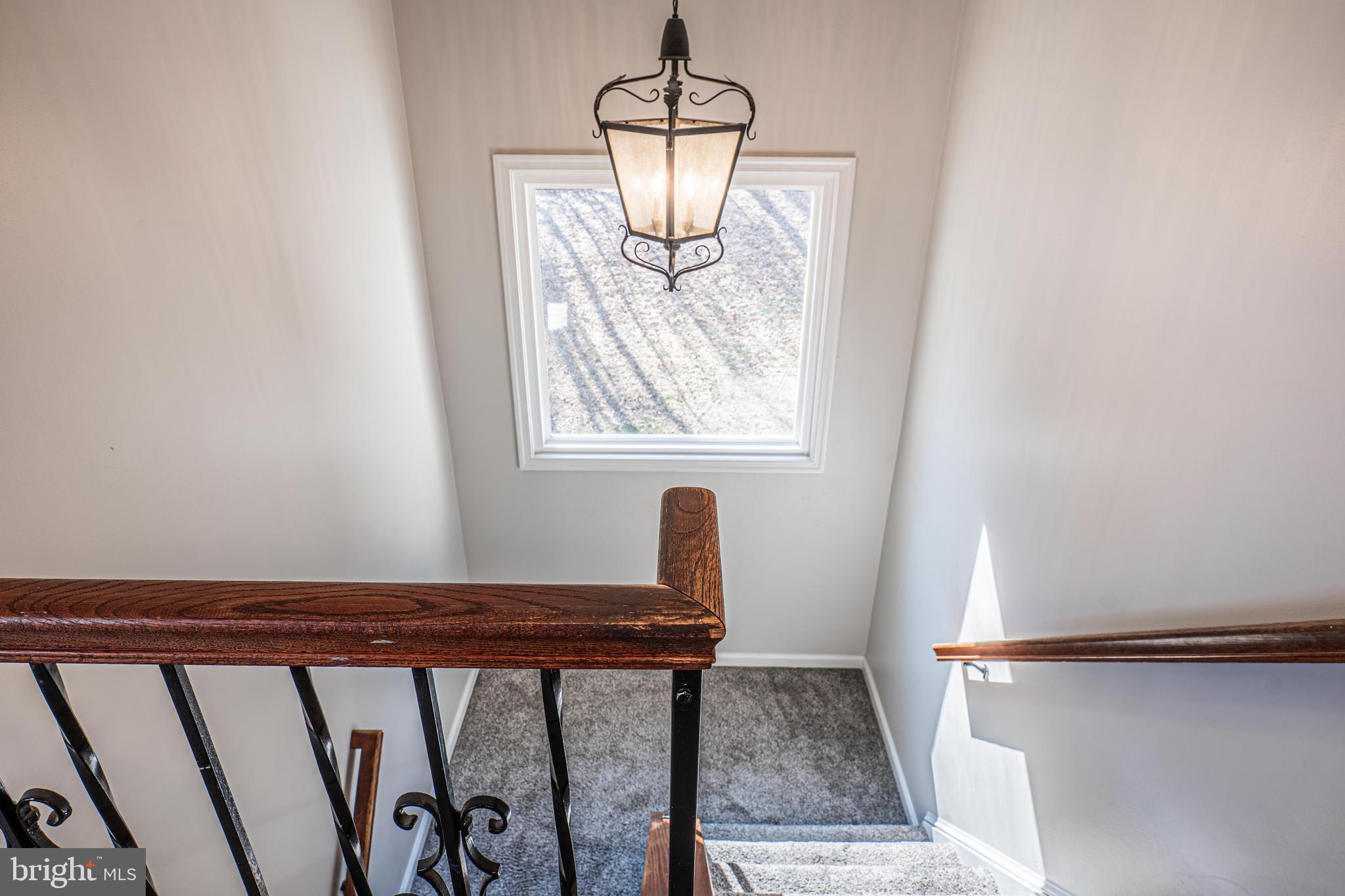 9833 Fox Road Frederick, MD 21702 - Photo 28 of 48 a view of a hallway with wooden floor and stairs