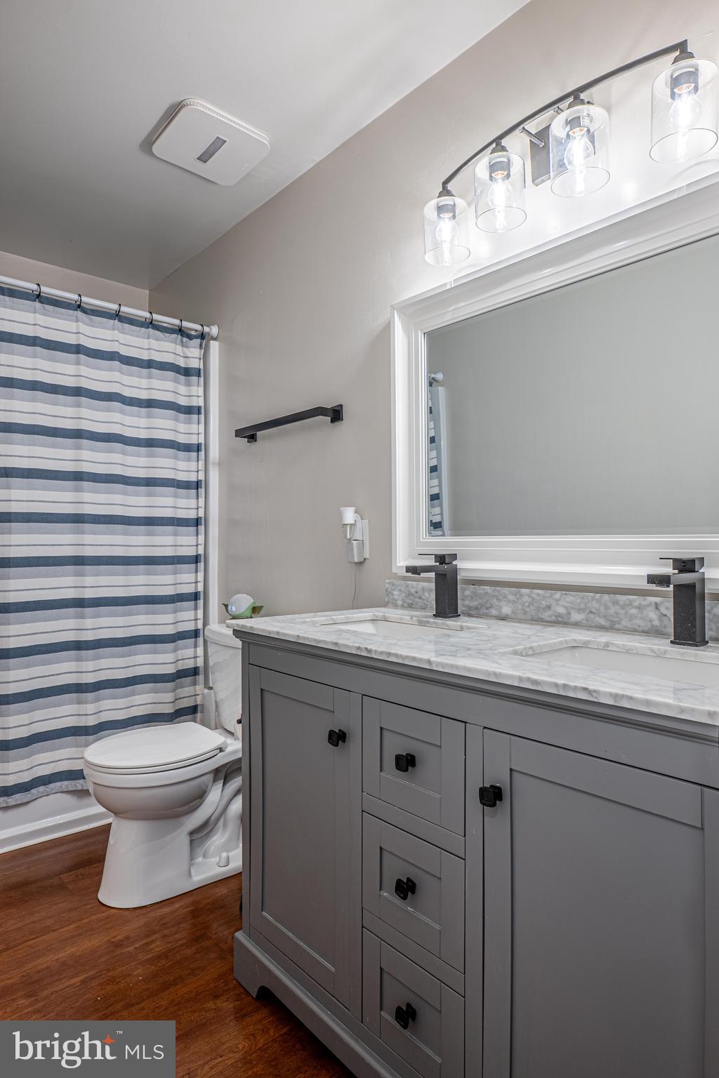 9833 Fox Road Frederick, MD 21702 - Photo 40 of 48 a bathroom with a granite countertop toilet a sink and a mirror