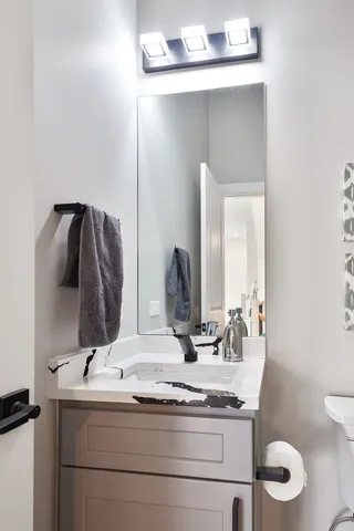 a bathroom with a granite countertop sink and a mirror