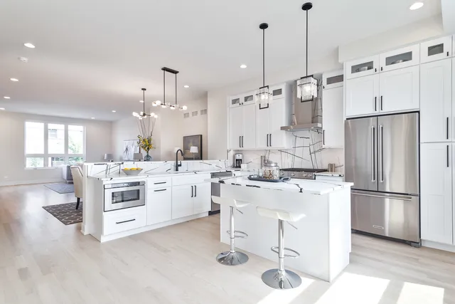 a kitchen with kitchen island a stove a refrigerator a sink dishwasher with a dining table and chairs